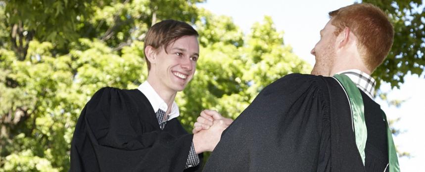 Image of two students holding each others hand on Graduation Ceremony 
