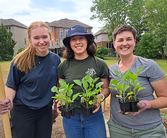 Three students work in the Tiny Home Takeout Garden